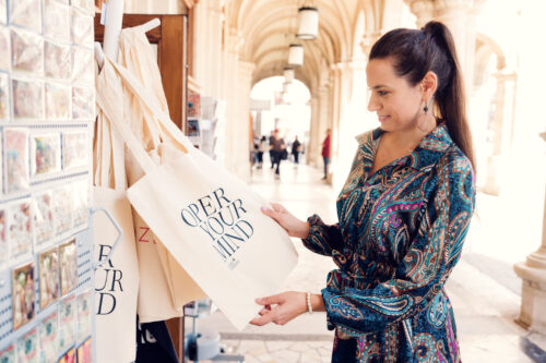 Adriana stöbert in Oper-Your-Mind-Stofftaschen im Souvenirshop der Wiener Staatsoper