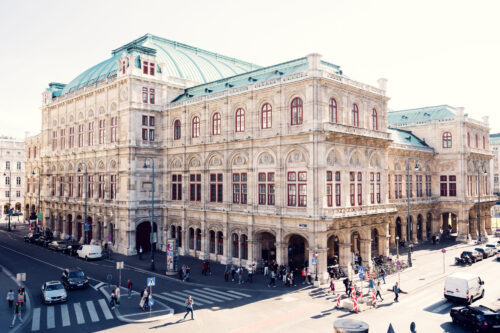 Erhöhter Blick auf die Wiener Staatsoper mit grünem Kupferdach und geschäftigem Straßenleben