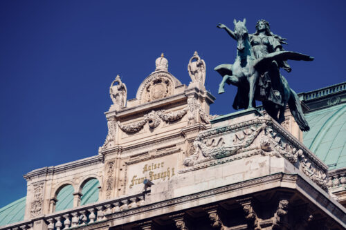 Nahaufnahme der Kaiser-Franz-Joseph-Inschrift und des bronzenen Pegasus-Reiters auf der Wiener Staatsoper