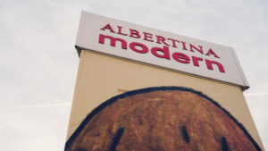 Albertina Modern sign with bold red lettering above a large-scale artwork on the facade.