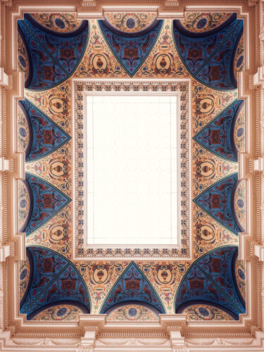 Ornate ceiling of the Künstlerhaus staircase hall, with geometric blue, gold, and terracotta patterns framing a central skylight.