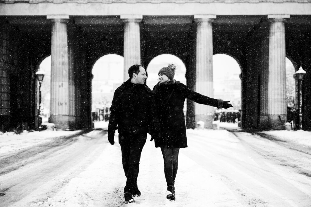 Adriana and Mario at snow-covered main gate of Heldenplatz, creating a magical winter scene.
