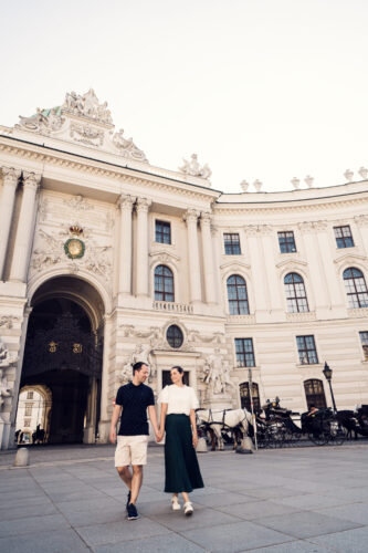 Hofburg Palace's main gate in summer, surrounded by bustling activity.