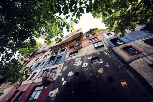 Main facade of Hundertwasserhaus where a rainbow of ceramic tiles dances across undulating walls.