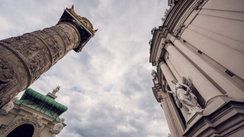 One of the ornate columns and the exterior facade of St. Charles Church (Karlskirche) in Vienna.