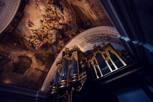 The grand organ inside St. Charles Church (Karlskirche), with its ornate golden pipes standing beneath a stunning baroque fresco.