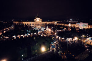 Vista nocturna del Museo de Historia del Arte de Viena con el mercado navideño en la Maria-Theresien-Platz.