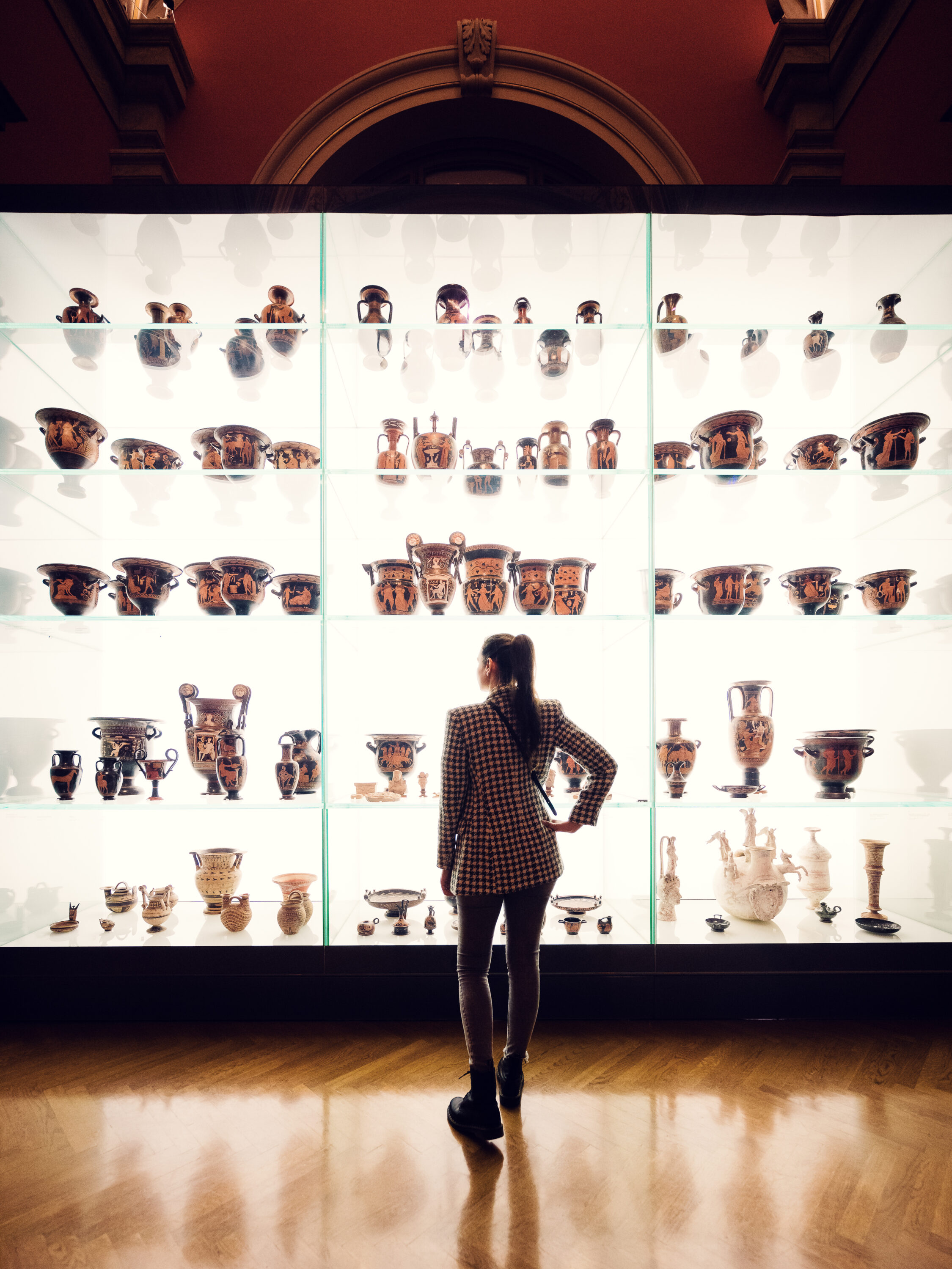 Adriana frente a una vitrina iluminada con antigüedades griegas en el Museo de Historia del Arte de Viena.