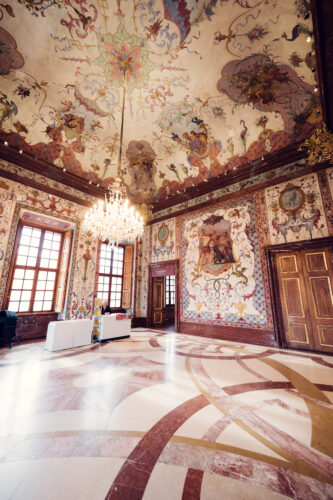 Elegant rooms in Lower Belvedere adorned with ornate wall panels and crystal chandeliers.