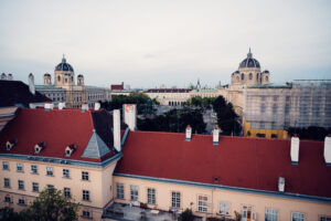 Sunset panorama from Libelle bar Vienna showing Museumsquartier courtyard with warm evening light and baroque museum buildings.