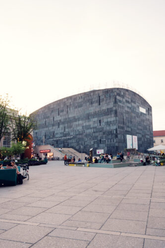 Corner view of MUMOK Vienna's angular basalt cube rising from the MuseumsQuartier courtyard.