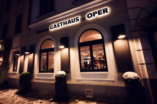 Evening winter scene with falling snow at Plachuttas Gasthaus zur Oper.