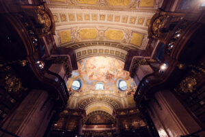 Baroque hall of the Prunksaal with marble columns rising to painted vaults in the Austrian National Library.