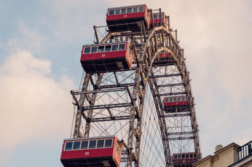 Intimate view of a vintage Giant Ferris Wheel (Wiener Riesenrad) cabins against the Vienna sky.