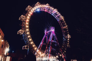 Night view of the Giant Ferris Wheel (Wiener Riesenrad), its illuminated cabins creating circles of light against Vienna's dark sky.