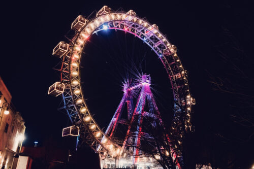 Night view of the Giant Ferris Wheel (Wiener Riesenrad), its illuminated cabins creating circles of light against Vienna's dark sky.