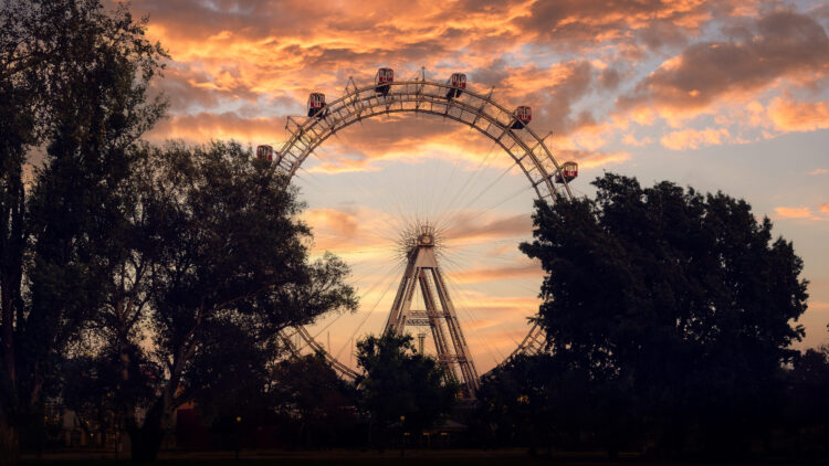 Golden hour light illuminating the historic Giant Ferris Wheel's (Wiener Riesenrad) distinctive silhouette.