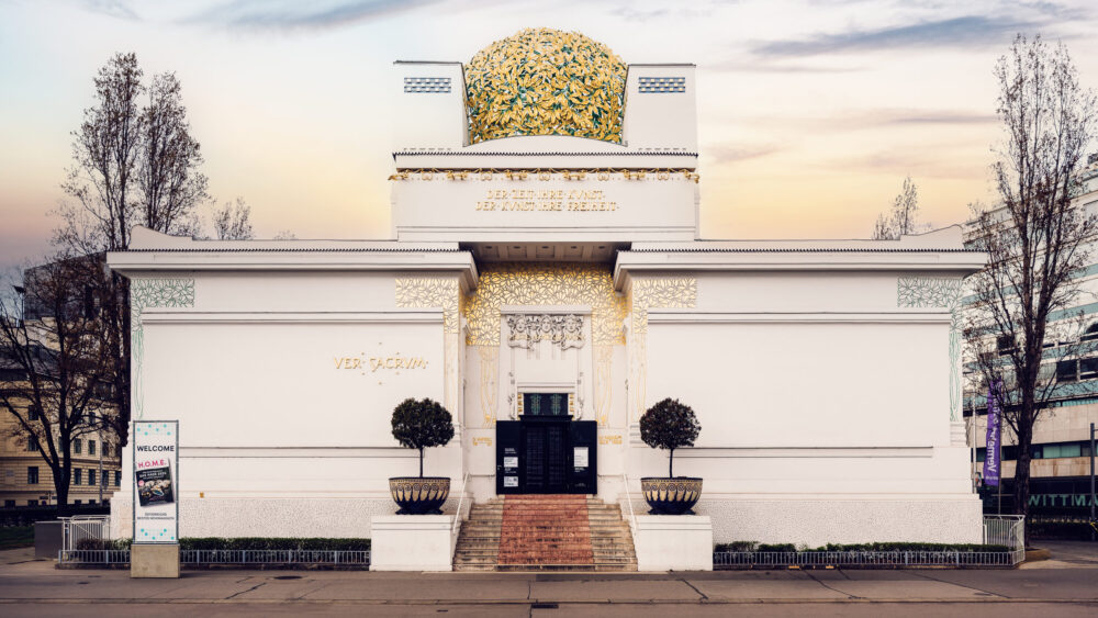 Vienna Secession Building entrance with ornate Art Nouveau details and the golden dome visible from Friedrichstraße.