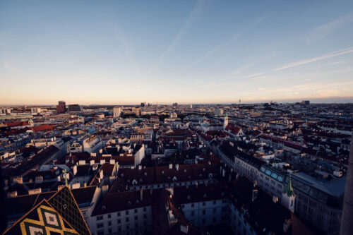 View through St. Stephen's Cathedral tower windows framing Vienna's rooftops.