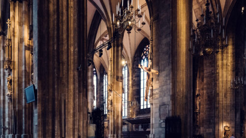 Columns inside St. Stephen's Cathedral with Gothic arches creating patterns of light and shadow.