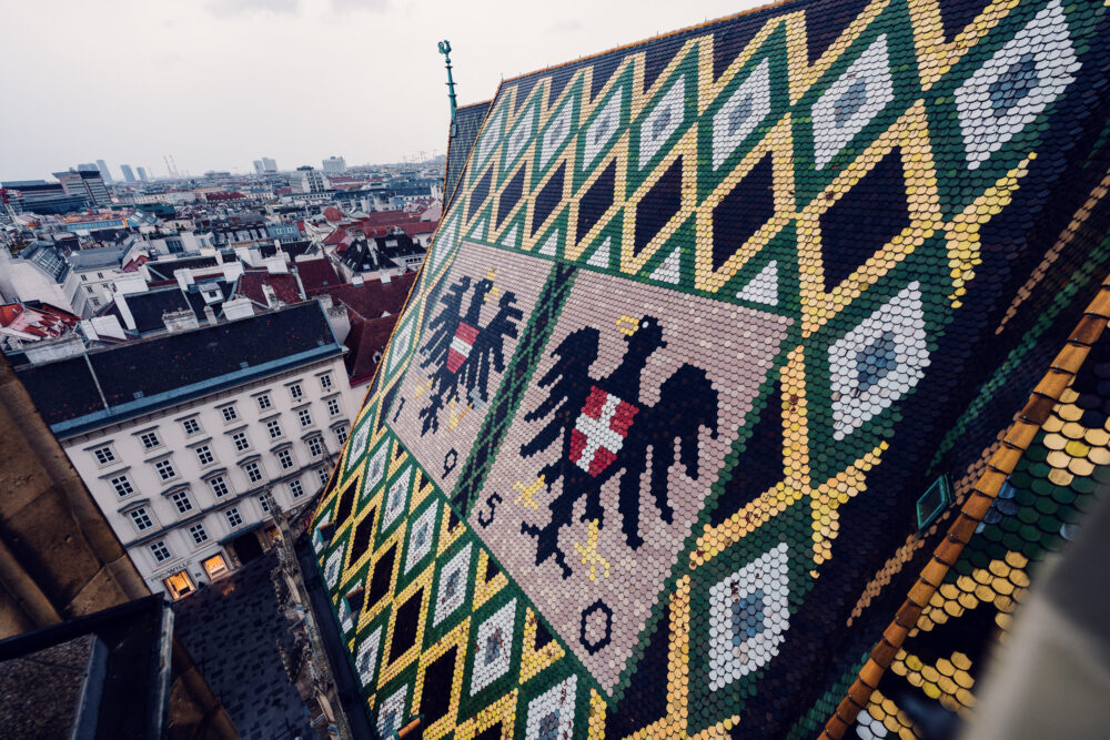 Iconic mosaic roof of St. Stephen's Cathedral, its 230,000 glazed tiles creating the distinctive double-headed eagle and Vienna's coat of arms.