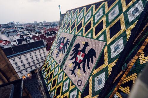 Iconic mosaic roof of St. Stephen's Cathedral, its 230,000 glazed tiles creating the distinctive double-headed eagle and Vienna's coat of arms.