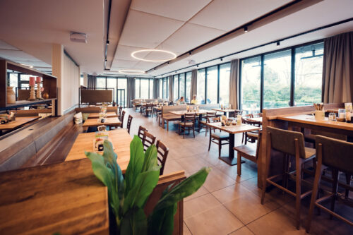 Main dining room of Stöckl im Park Vienna with original woodwork and contemporary interior design.