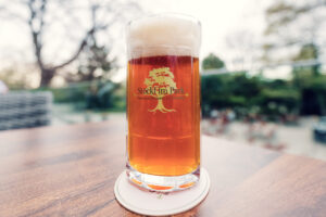Austrian craft beer served in traditional glass at Stöckl im Park's garden terrace.