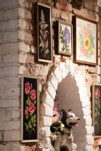 The vintage-style needlework and quirky decor add to the café's charming, nostalgic atmosphere, creating a welcoming and homey vibe.