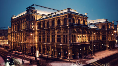 Vienna State Opera in winter with a blanket of snow on the rooftops.
