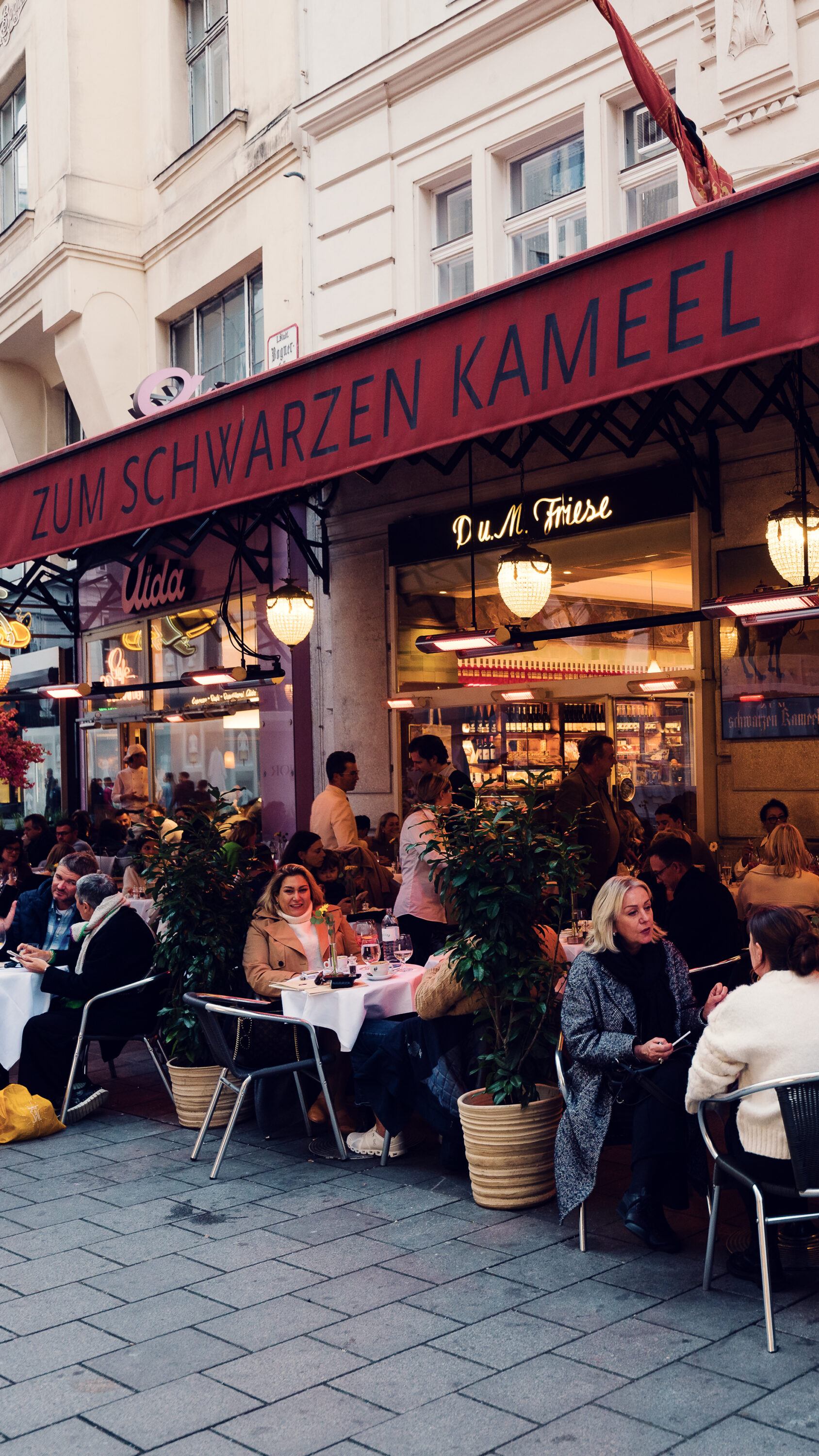 A lively street scene in front of the Viennese restaurant Zum Schwarzen Kameel