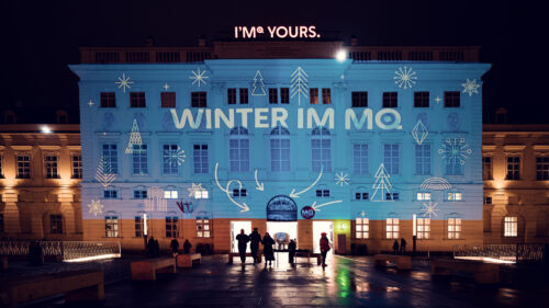 Evening glow of MuseumsQuartier's winter lighting design highlighting architectural features and cultural spaces.