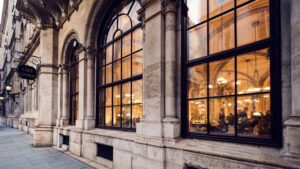 Luce calda della sera attraverso le finestre ad arco del Café Central nel Palais Ferstel.