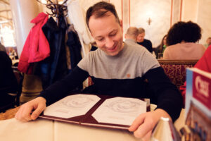 Mario sfoglia il menu del Café Central con un sorriso.