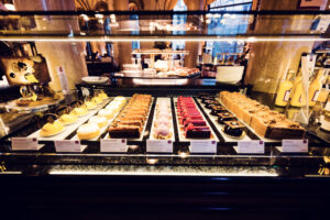 Vetrina dei dolci al Café Central con file di tartine colorate, torte e petit four.