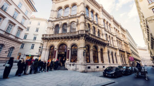 Coda di visitatori davanti al Café Central nel Palais Ferstel con un Fiaker di passaggio.