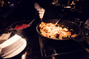 Kaiserschmarrn en préparation dans une poêle avec compote de fruits rouges dans la cuisine ouverte du Café Demel.