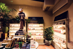 Espace chocolaterie du Café Demel avec une figurine décorative et des étagères de pralinés.