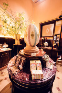 Oeuf de Pâques décoratif sur une table en marbre entouré de coffrets cadeaux au Café Demel.