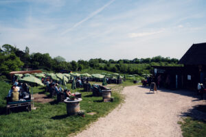 Wide view of the terrace at Mayer am Nussberg with green sunshades and vineyard-covered hills.