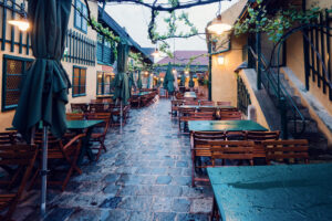 Seating area on the garden terrace of Heuriger Mayer am Pfarrplatz surrounded by green plants.