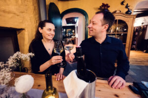 Two guests toasting with wine glasses at Heuriger Mayer am Pfarrplatz.