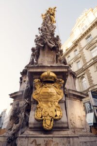 The coats of arms on the Pestsäule represent the Habsburg Monarchy and emphasize the emperor’s role as a ruler chosen by God.