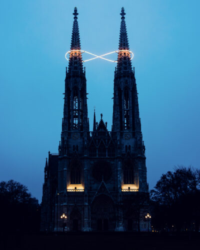 Front view of Vienna’s Votive Church with Infinity of Light by Billi Thanner illuminated between the two spires.