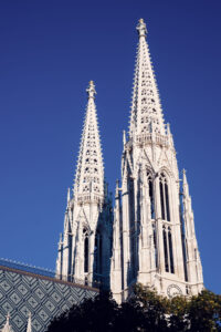 Votivkirche Vienna's neo-Gothic spires with their intricate openwork design capturing the golden summer evening light.