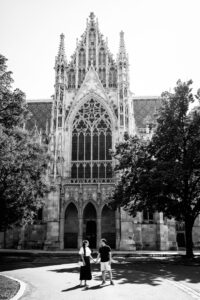 Adriana and Mario sharing a moment beneath the towering neo-Gothic architecture of Votivkirche Vienna (Votive Church).