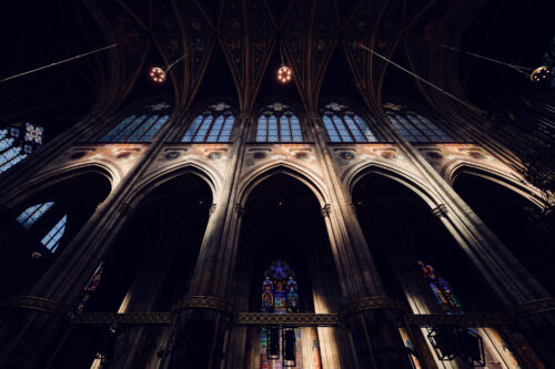 Slender clustered columns of Votivkirche Vienna rising dramatically from the marble floor to support the ribbed vaulting.