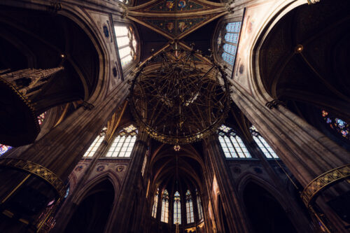 Vue en contre-plongée de la voûte et du lustre à l'intérieur de la Votivkirche de Vienne.