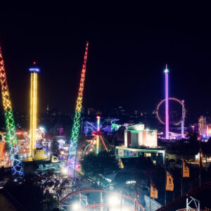 Wiener Prater bei Nacht mit beleuchteten Fahrgeschäften und festlicher Beleuchtung.