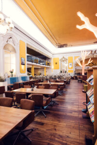 Seating area with leather chairs beneath the golden ceiling at Brandauer's Schlossbräu.